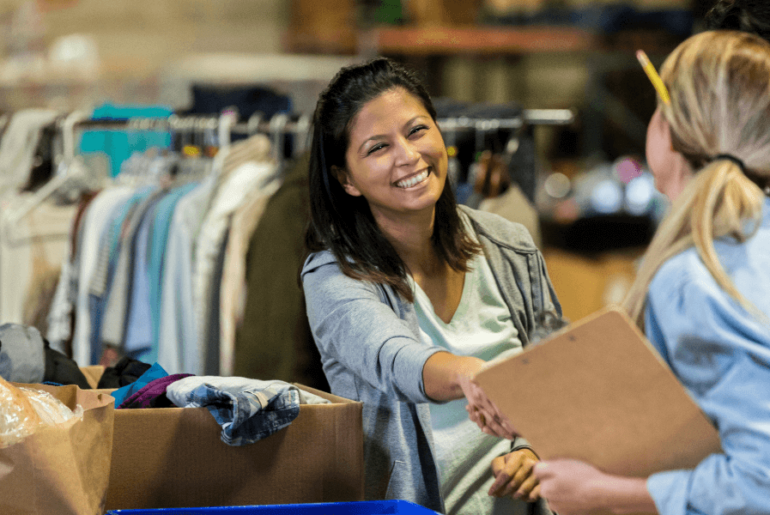 Happy volunteer at clothing drive shaking hands