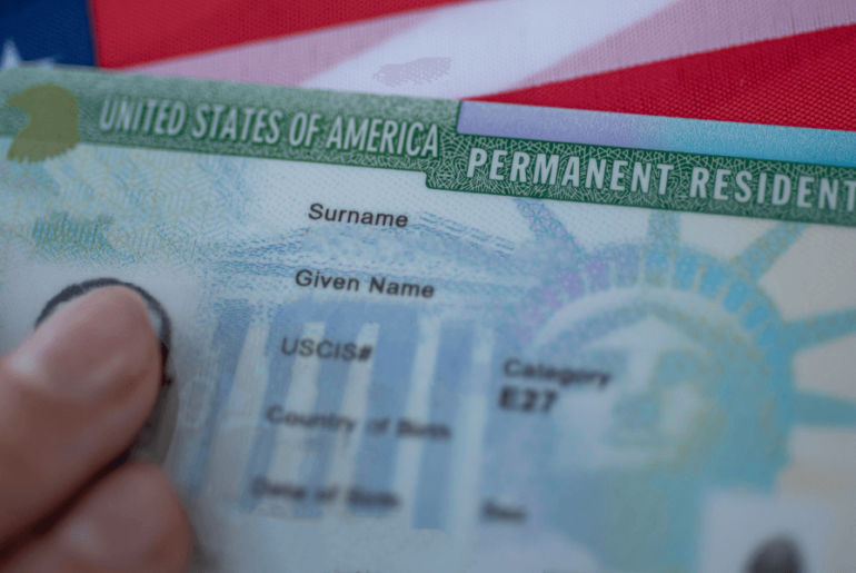 Green card and USA flag - Maintaining Your U.S. Residency